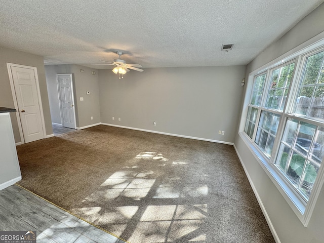 carpeted spare room with ceiling fan and a textured ceiling