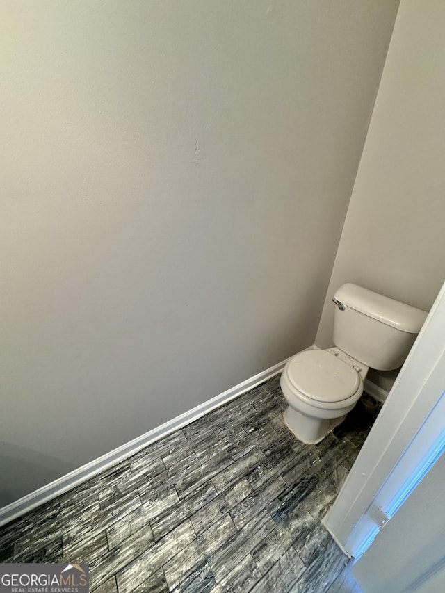 bathroom featuring wood-type flooring and toilet