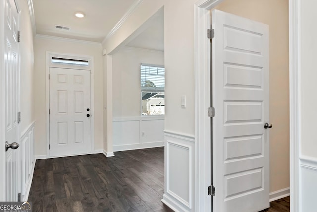 foyer with ornamental molding and dark hardwood / wood-style floors