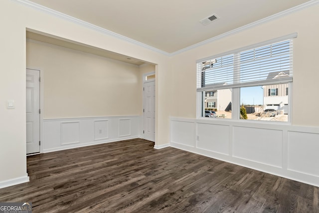 empty room featuring dark wood-type flooring and ornamental molding