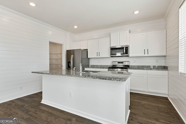 kitchen featuring dark hardwood / wood-style flooring, sink, appliances with stainless steel finishes, white cabinetry, and a center island with sink