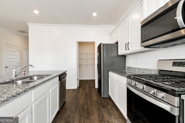 kitchen featuring sink, white cabinets, ornamental molding, stainless steel appliances, and light stone counters