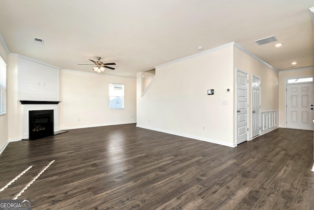 unfurnished living room with ceiling fan, dark wood-type flooring, and crown molding