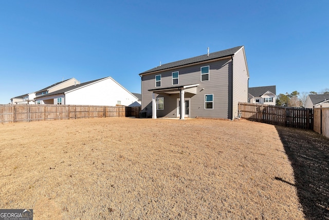 rear view of property with a yard