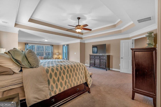 carpeted bedroom with ceiling fan, ornamental molding, and a tray ceiling