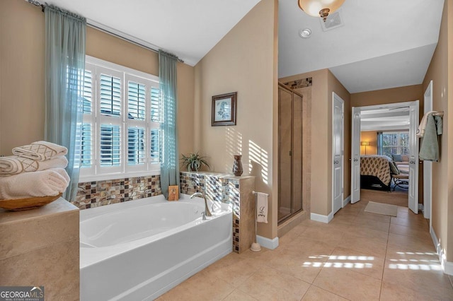 bathroom featuring tile patterned flooring, vaulted ceiling, and shower with separate bathtub