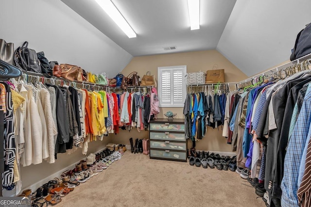 walk in closet featuring vaulted ceiling and carpet floors