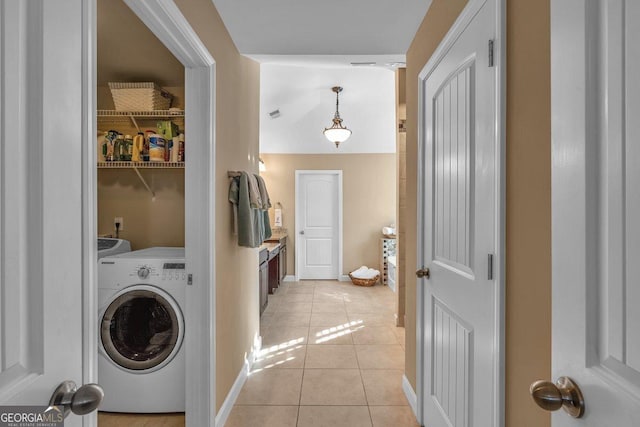 clothes washing area featuring washer / clothes dryer and light tile patterned flooring