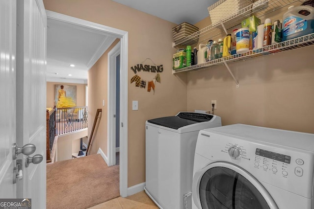 laundry area featuring light carpet, crown molding, and washing machine and clothes dryer