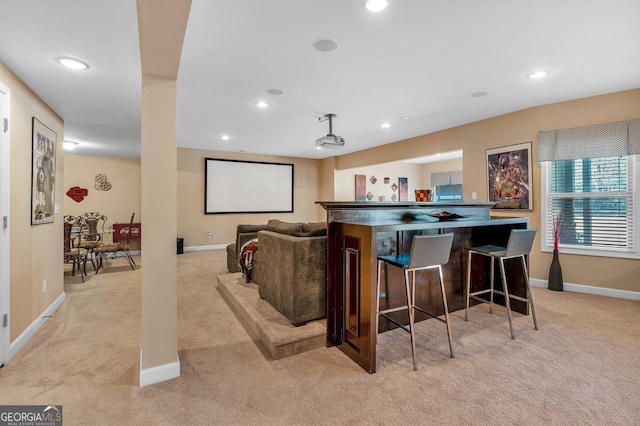 carpeted cinema room featuring bar