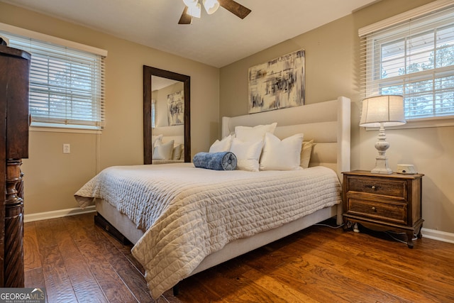 bedroom with ceiling fan, multiple windows, and dark hardwood / wood-style flooring