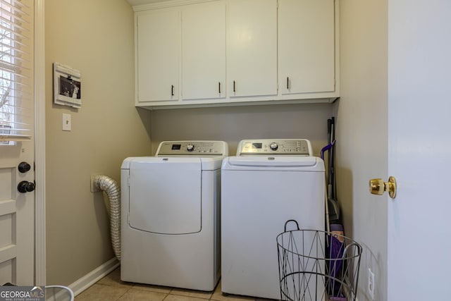 washroom with light tile patterned floors, cabinets, and washer and clothes dryer
