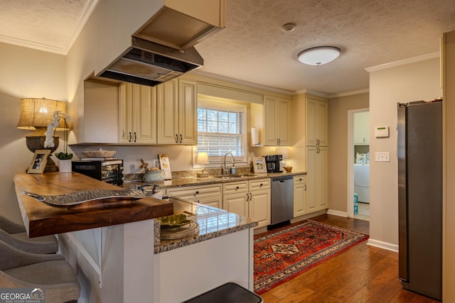 kitchen featuring appliances with stainless steel finishes, sink, premium range hood, a textured ceiling, and stone counters