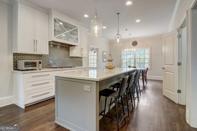 kitchen with white cabinetry, a center island, tasteful backsplash, and a breakfast bar