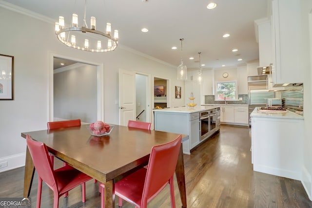 dining room with sink, dark hardwood / wood-style flooring, and ornamental molding