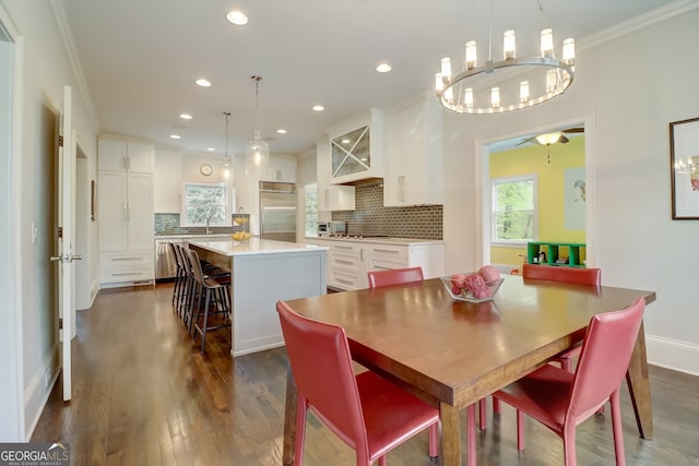 dining space featuring dark wood-type flooring, plenty of natural light, and crown molding