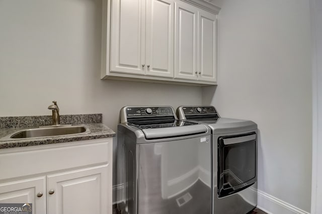 laundry room featuring cabinets, sink, and separate washer and dryer