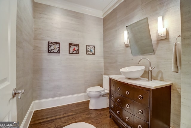 bathroom with wood-type flooring, toilet, vanity, and crown molding