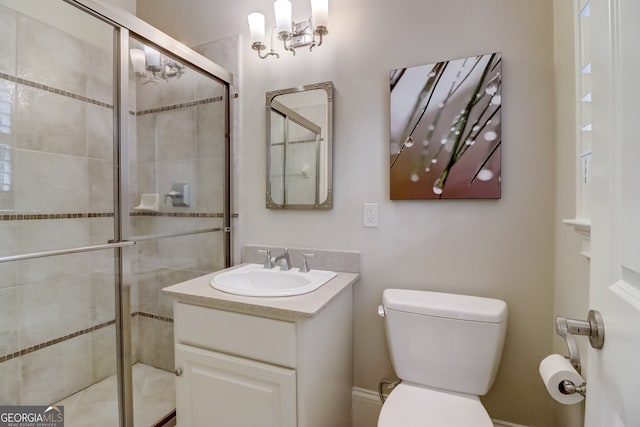 bathroom featuring vanity, toilet, and a shower with door