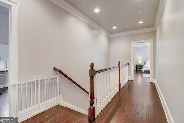 hall with dark wood-type flooring and crown molding