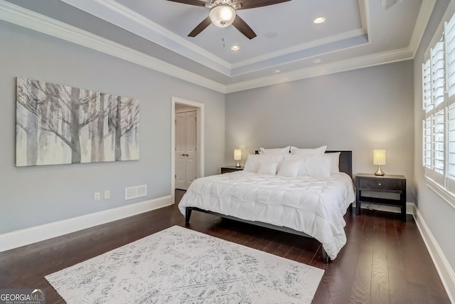 bedroom with ceiling fan, a raised ceiling, crown molding, and dark hardwood / wood-style floors