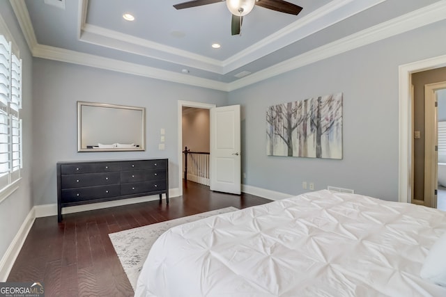 bedroom featuring dark hardwood / wood-style flooring, a tray ceiling, ceiling fan, and ornamental molding