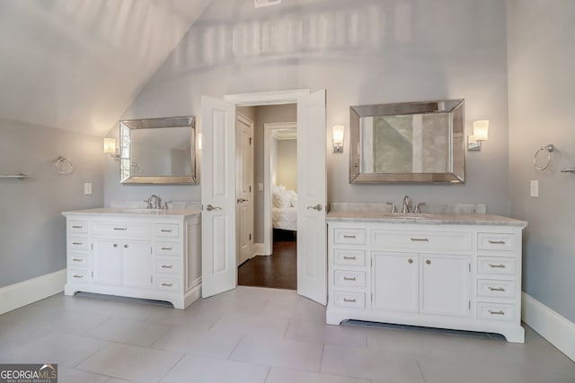 bathroom with tile patterned flooring, vanity, and vaulted ceiling