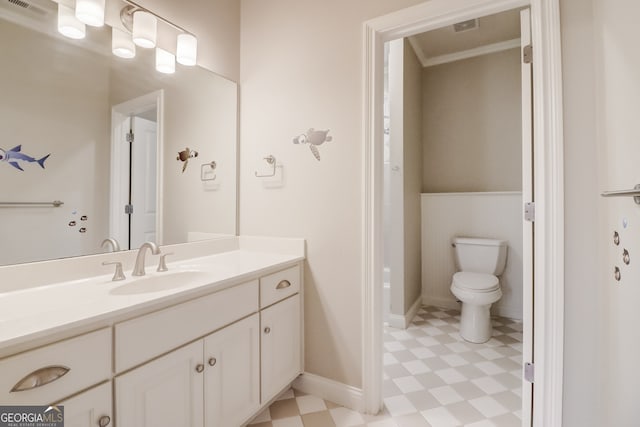 bathroom with vanity, toilet, and crown molding