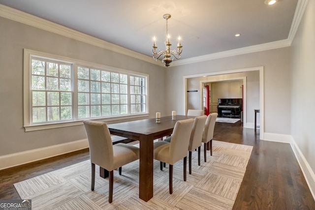 dining room featuring wood-type flooring, a notable chandelier, and ornamental molding