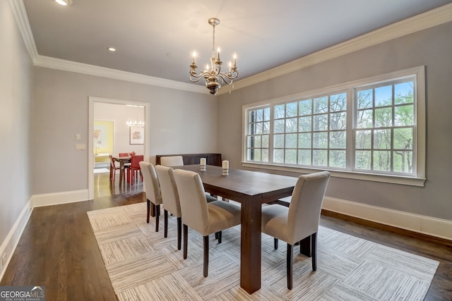 dining space featuring hardwood / wood-style floors, crown molding, and a notable chandelier