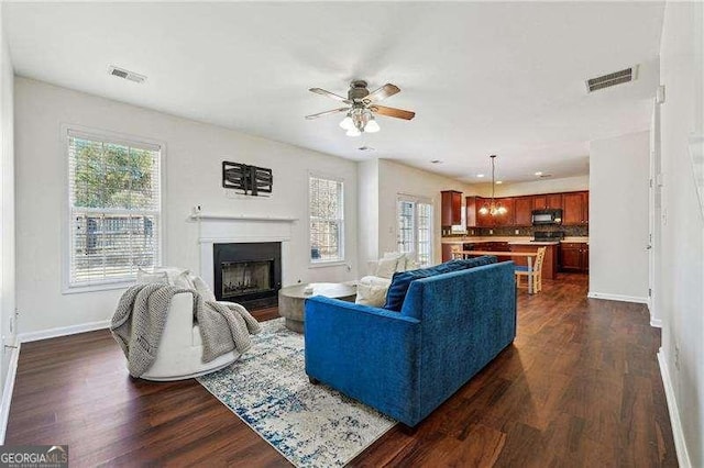 living room featuring ceiling fan and dark hardwood / wood-style floors