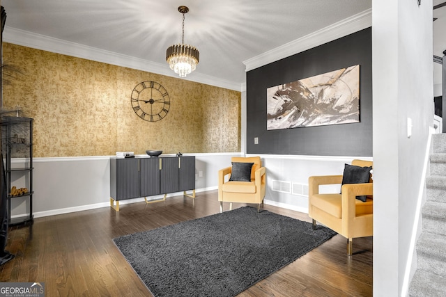 living area with ornamental molding, dark hardwood / wood-style floors, and an inviting chandelier