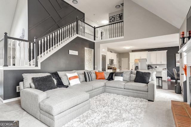 carpeted living room featuring a high ceiling