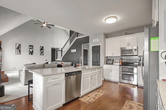 kitchen featuring sink, ceiling fan, appliances with stainless steel finishes, white cabinetry, and light stone countertops