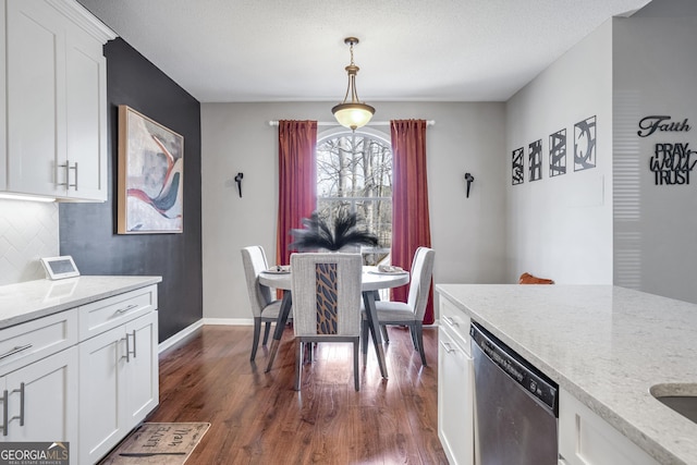 dining area with dark wood-type flooring and a textured ceiling