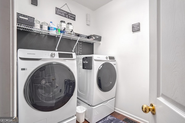 laundry room with washing machine and clothes dryer and hardwood / wood-style floors