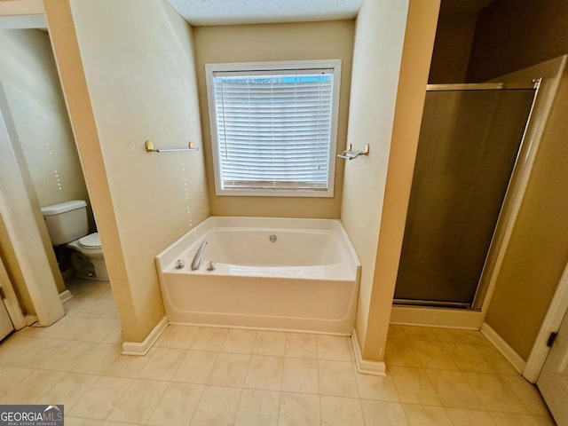 bathroom featuring toilet, tile patterned flooring, and shower with separate bathtub