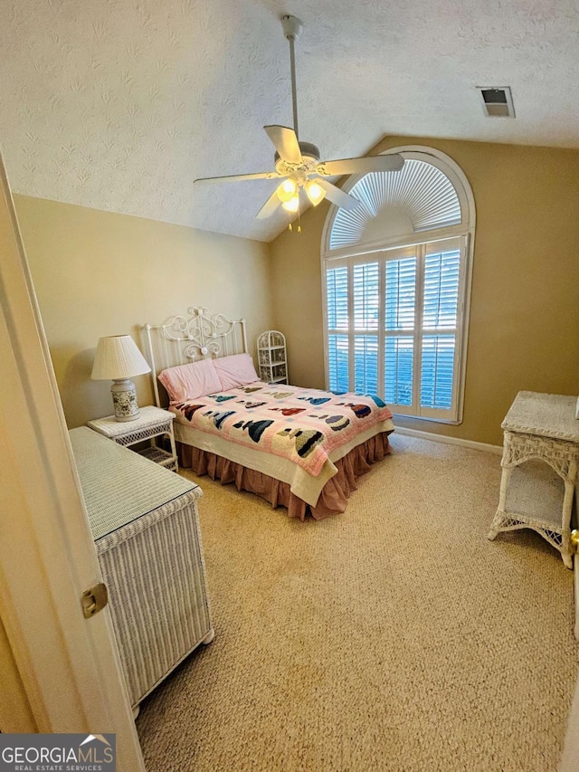 bedroom featuring ceiling fan, carpet floors, a textured ceiling, and lofted ceiling