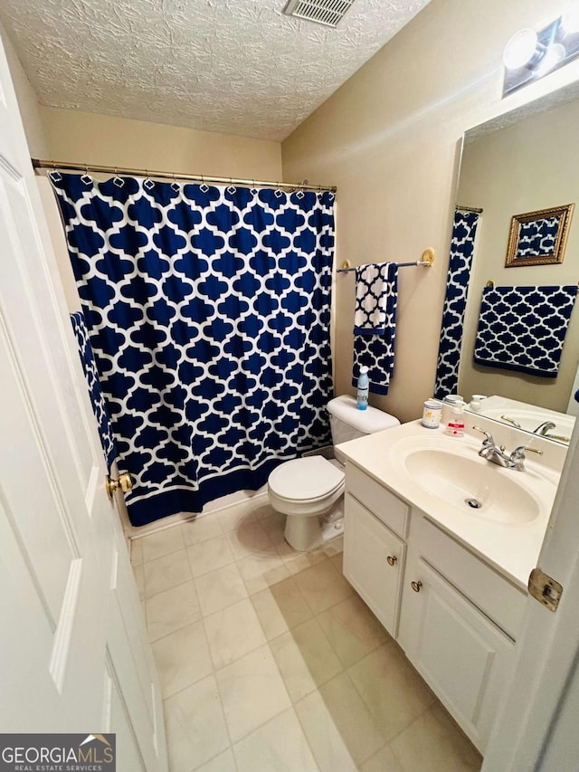 bathroom with a textured ceiling, toilet, and vanity