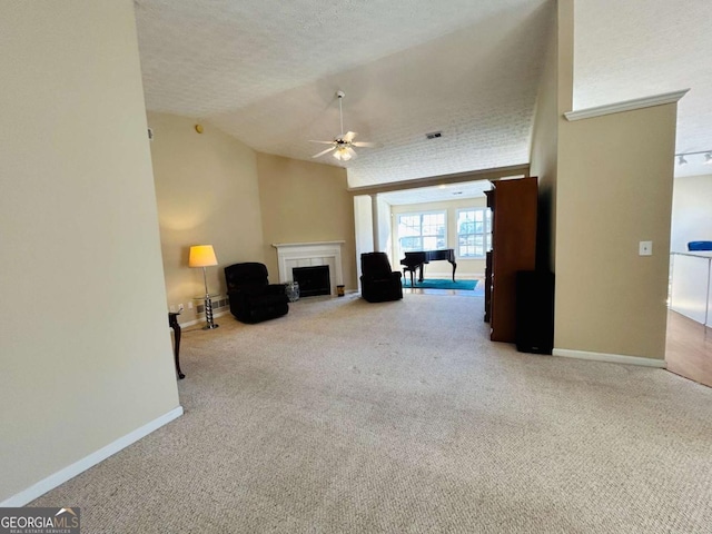 unfurnished living room with lofted ceiling, ceiling fan, a textured ceiling, and carpet