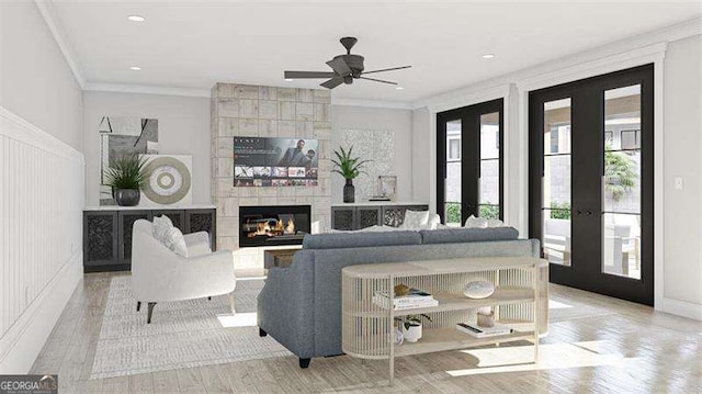 living room with ceiling fan, french doors, ornamental molding, and a tiled fireplace