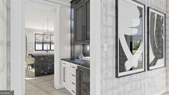 kitchen with pendant lighting, white cabinetry, beverage cooler, and a healthy amount of sunlight