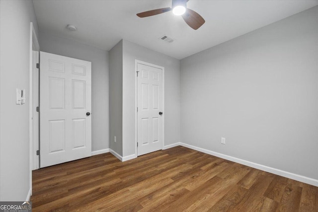 unfurnished bedroom featuring ceiling fan and dark wood-type flooring