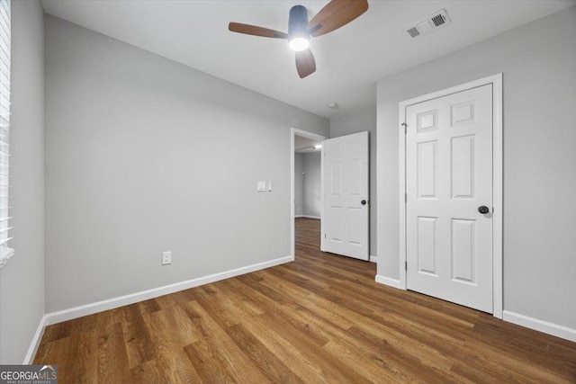 unfurnished bedroom with ceiling fan and wood-type flooring