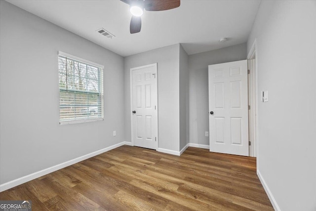 unfurnished bedroom featuring wood-type flooring, a closet, and ceiling fan