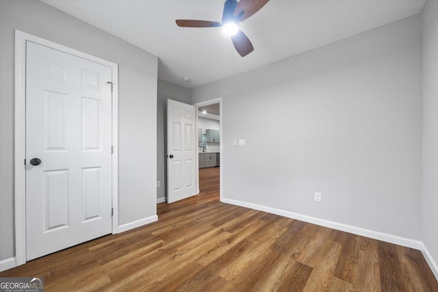 unfurnished bedroom with ceiling fan and hardwood / wood-style floors