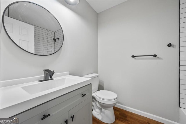 bathroom featuring vanity, toilet, walk in shower, and wood-type flooring