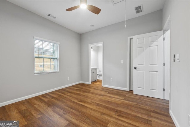 unfurnished bedroom with ceiling fan, connected bathroom, and dark hardwood / wood-style flooring