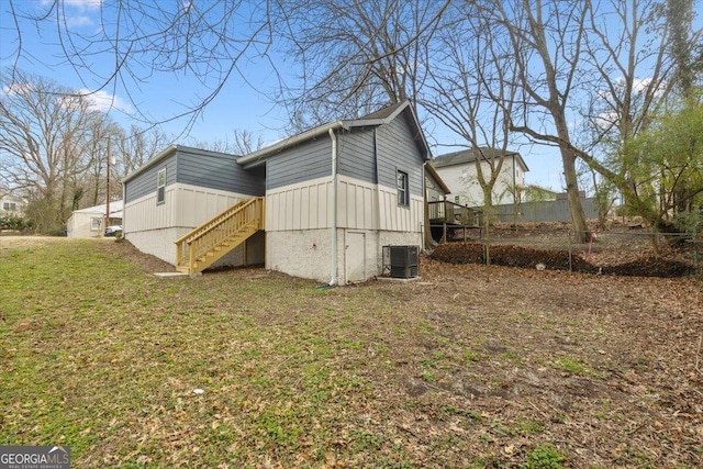 view of property exterior with central air condition unit and a yard