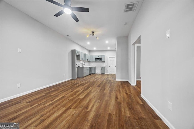 unfurnished living room featuring sink, ceiling fan, and dark hardwood / wood-style flooring